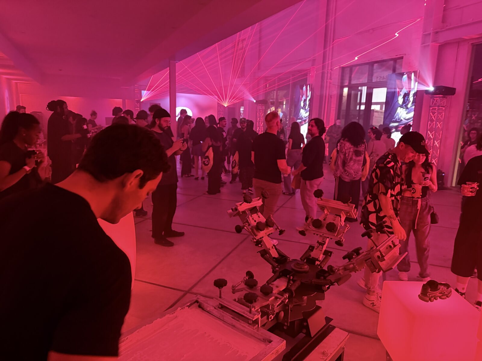 Live station running during a pink-lit after-party with guests gathered around