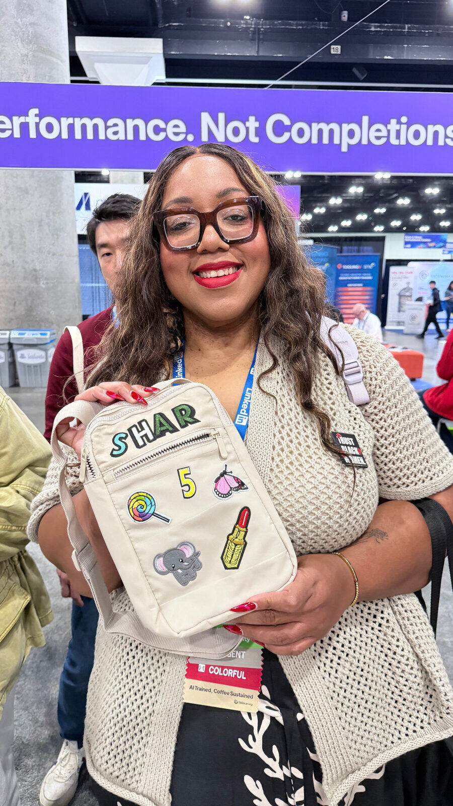 Guest showing off a crossbody bag monogrammed with varsity letter patches spelling STAR at a live personalization station