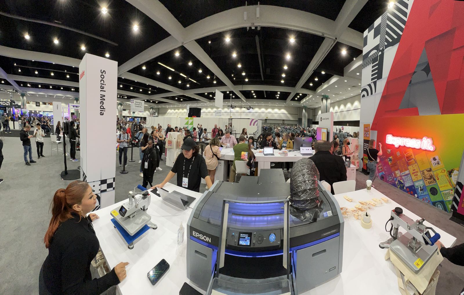 Row of professional heat press stations set up across a large venue floor